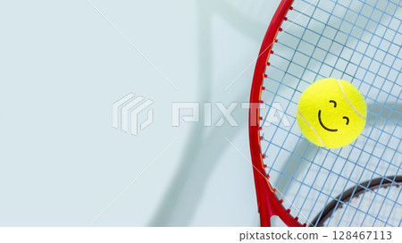 Tennis competition banner. Sport composition with yellow tennis ball with smile face and tennis rackets on a blue background with copy space. Sport and healthy lifestyle. Sport with positive emotions 128467113
