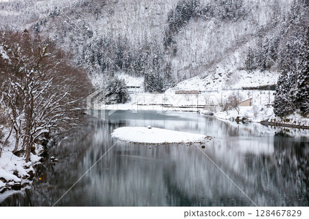 [Takayama Main Line] A local train running through the snowy landscape of Oku-Hida 128467829