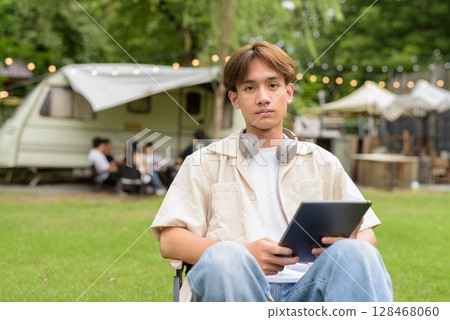 Young non binary person having road trip and camping with friends in nature 128468060