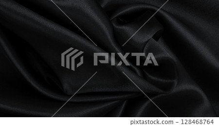 Smooth elegant black silk or satin luxury cloth texture as abstract background. Luxurious background design 128468764