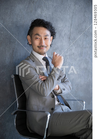 一位西裝革履的商人坐在椅子上思考。成功、目標、策略和策略規劃的垂直圖像 128469305