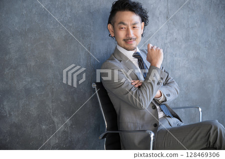 一位西裝革履的商人坐在椅子上思考。成功、目標、策略和策略規劃的圖片。 128469306