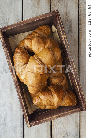Close-up of croissants on a dark background. Fresh and delicious French pastries, bakery concept, close-up image. tea . Close-up of croissants on a dark background. Fresh and delicious French pastries, bakery concept, close-up image. tea . 128469464