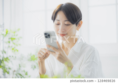 觀看智能手機的婦女 觀看智能手機的婦女 128469816