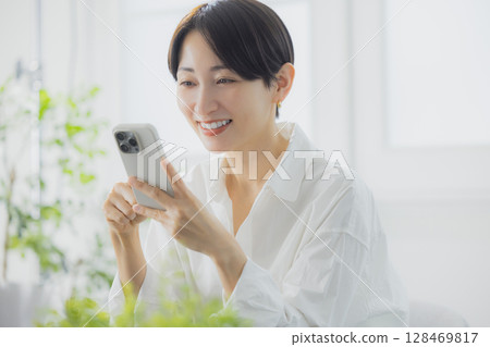 A woman watching a smartphone 128469817