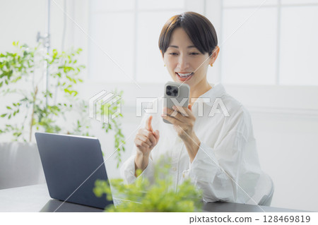 A woman watching a smartphone A woman watching a smartphone 128469819