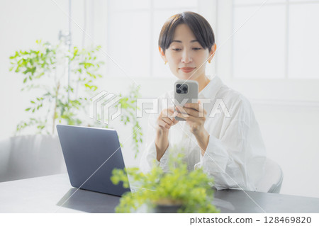 A woman watching a smartphone 128469820