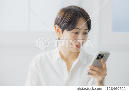 A woman watching a smartphone A woman watching a smartphone 128469821
