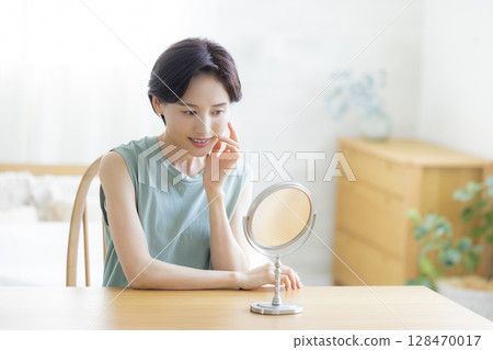 一位女士在臥室裡做皮膚護理 一位女士在臥室裡做皮膚護理 128470017