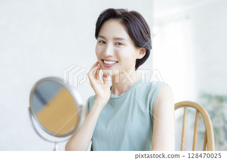 一位女士在臥室裡做皮膚護理 一位女士在臥室裡做皮膚護理 128470025