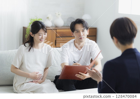 一對夫婦正在與一位西裝革履的女士進行諮詢 一對夫婦正在與一位西裝革履的女士進行諮詢 128470084