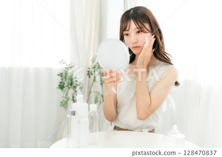 A woman who uses skin care products to moisturize her skin (skin problems, rough skin) 128470837