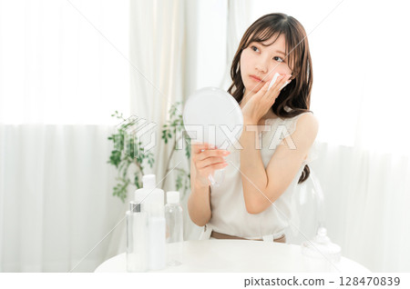 A woman who uses skin care products to keep her skin moisturized (skin problems, worries) 128470839