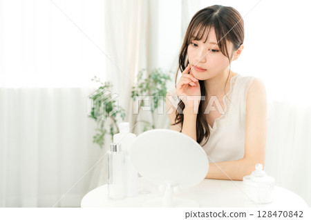 年輕的亞洲女性對著鏡子檢查自己粗糙的皮膚和皮膚問題 128470842