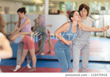 Women practice self-defense techniques in pairs Women practice self-defense techniques in pairs 128470916