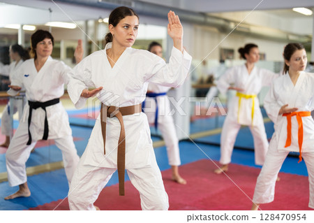 Women in self-defense training in white kimono with belts 128470954