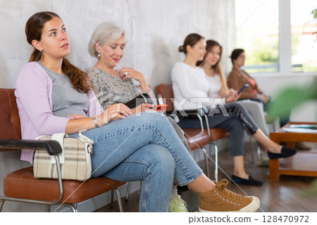 Bored mature skilled lady executive manager sitting in chair waiting meeting recruiter. 128470972