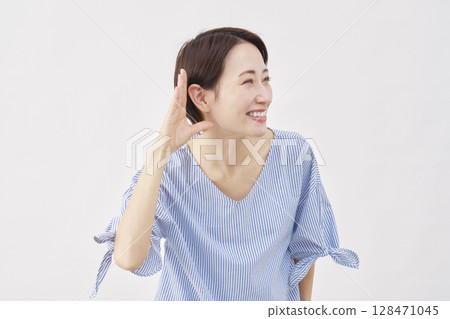 中年婦女，用手摀住耳朵聆聽的姿勢，白色背景 128471045