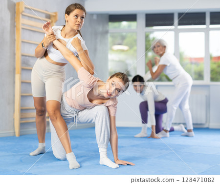 Girl and woman train of performing protection with wring hands during training in self-defense 128471082