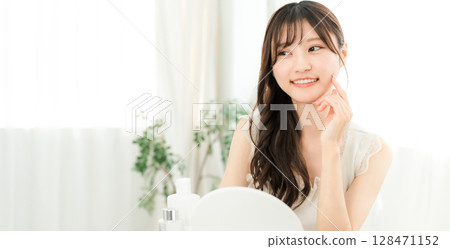 Young Asian woman using skin care products and cosmetics for moisturizing, skincare and anti-aging 128471152