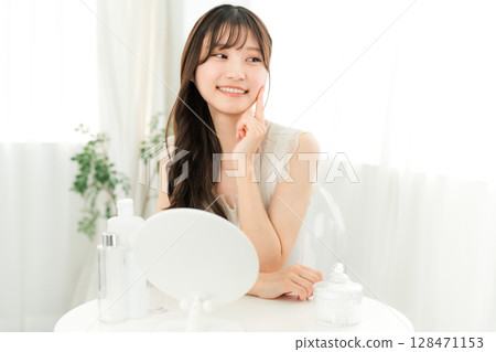 一位年輕的亞洲女性使用基本化妝品來保濕、護膚和抗衰老。 128471153