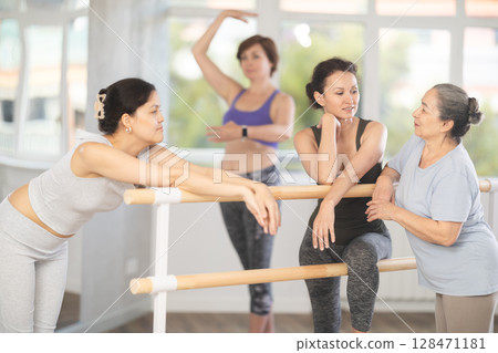 Women communicate with each other during a break between classes in choreographic studio Women communicate with each other during a break between classes in choreographic studio 128471181