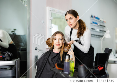 Young woman client is discussing a haircut with a hairdresser Young woman client is discussing a haircut with a hairdresser 128471239