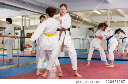 Women practicing a body punch in training 128471267