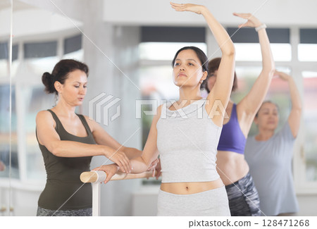 Choreographer coach teaches amateur students to keep their heads straight during ballet lesson Choreographer coach teaches amateur students to keep their heads straight during ballet lesson 128471268