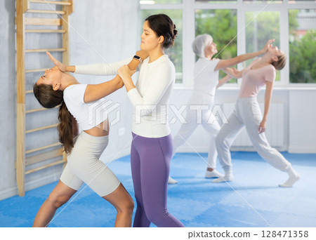 Woman practices blows to head of her attacking woman during self defense training Woman practices blows to head of her attacking woman during self defense training 128471358