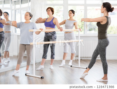 Female amateurs of choreographic lesson learn from experienced coach of theatrical dance Female amateurs of choreographic lesson learn from experienced coach of theatrical dance 128471366