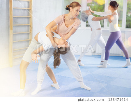 Two young women training self-defense techniques 128471414