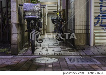 After the rain, at night, an alley leading to an apartment building 128471631