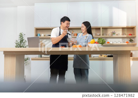 Couple Sharing Cooking Tips and Ingredients in Bright Kitchen 128471982