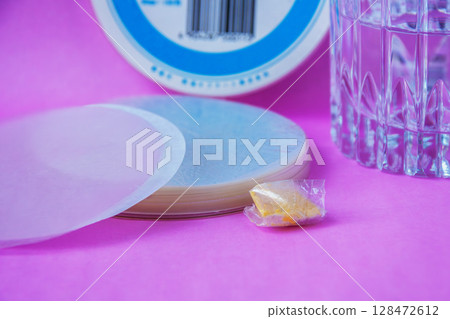 Medicinal wafer, a cup of water, and powdered medicine wrapped in the wafer Medicinal wafer, a cup of water, and powdered medicine wrapped in the wafer 128472612