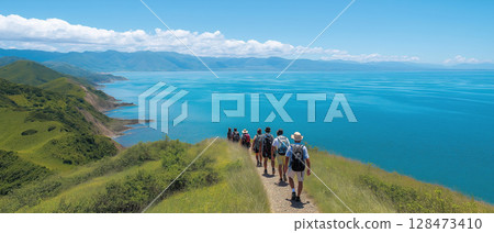 Group of hikers walking along scenic coastal trail with blue sea and green hills under clear sky Group of hikers walking along scenic coastal trail with blue sea and green hills under clear sky 128473410
