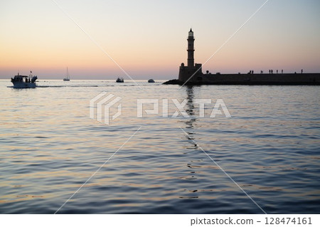 Lighthouse and Boats at Sunset in Calm Harbor 128474161
