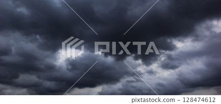A dark, cloud filled sky creates a foreboding atmosphere, symbolizing the dramatic effects of changing climate patterns and the uncertainties associated with global warming. A dark, cloud filled sky creates a foreboding atmosphere, symbolizing the dramatic effects of changing climate patterns and the uncertainties associated with global warming. 128474612