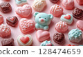 A delightful arrangement of pastel colored heart-shaped chocolates and a cute blue teddy bear-shaped candy on a soft pink background, creating a charming Valentines Day treat display. 128474659