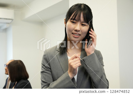A woman talking on a smartphone in a conference room 128474852