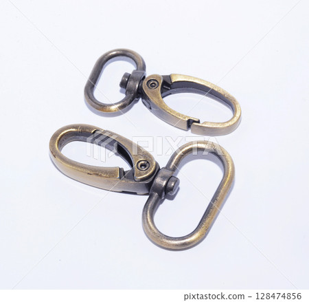 Brass lobster claw clasp or swivel hooks isolated on white. Brass lobster claw clasp or swivel hooks isolated on white. 128474856