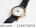 Stainless steel analog watch with black leather strap. Vintage analog watch. Leather band wristwatch. 128474858