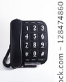 Black analog desk or wall telephone and handset receiver with curly cord on white background. 128474860