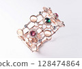Bracelet with colorful crystals caged in rose-colored plated metal alloy. 128474864