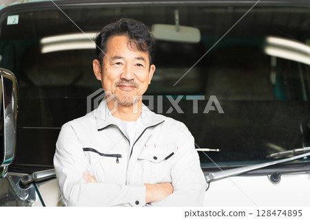 一名中年男子在卡車前擺姿勢的施工影像 一名中年男子在卡車前擺姿勢的施工影像 128474895