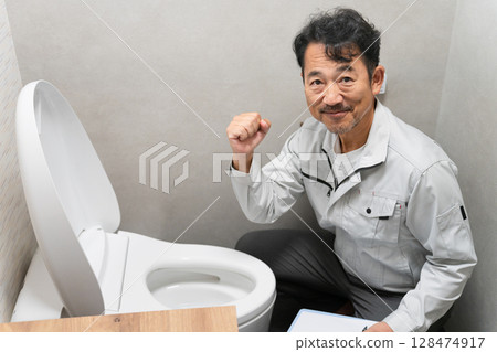 Repairman inspecting the toilet Lifestyle image Repairman inspecting the toilet Lifestyle image 128474917