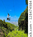 Ropeway emerging from a mountain valley 128474984