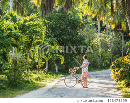Handsome man with vintage bicycle. Clear, sunny day Handsome man with vintage bicycle. Clear, sunny day 128475269