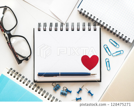 Blank notepad page and red heart drawing 128475271