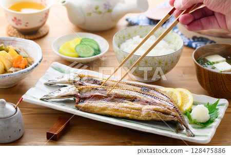 熱騰騰的日式早餐：桌上的烤魚（秋刀魚片）、米飯和味噌湯 128475886